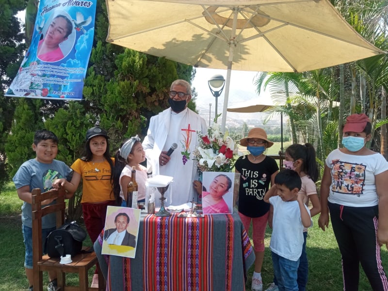 Fr Iowane with children at an outdoor Mass in Lima, Peru.